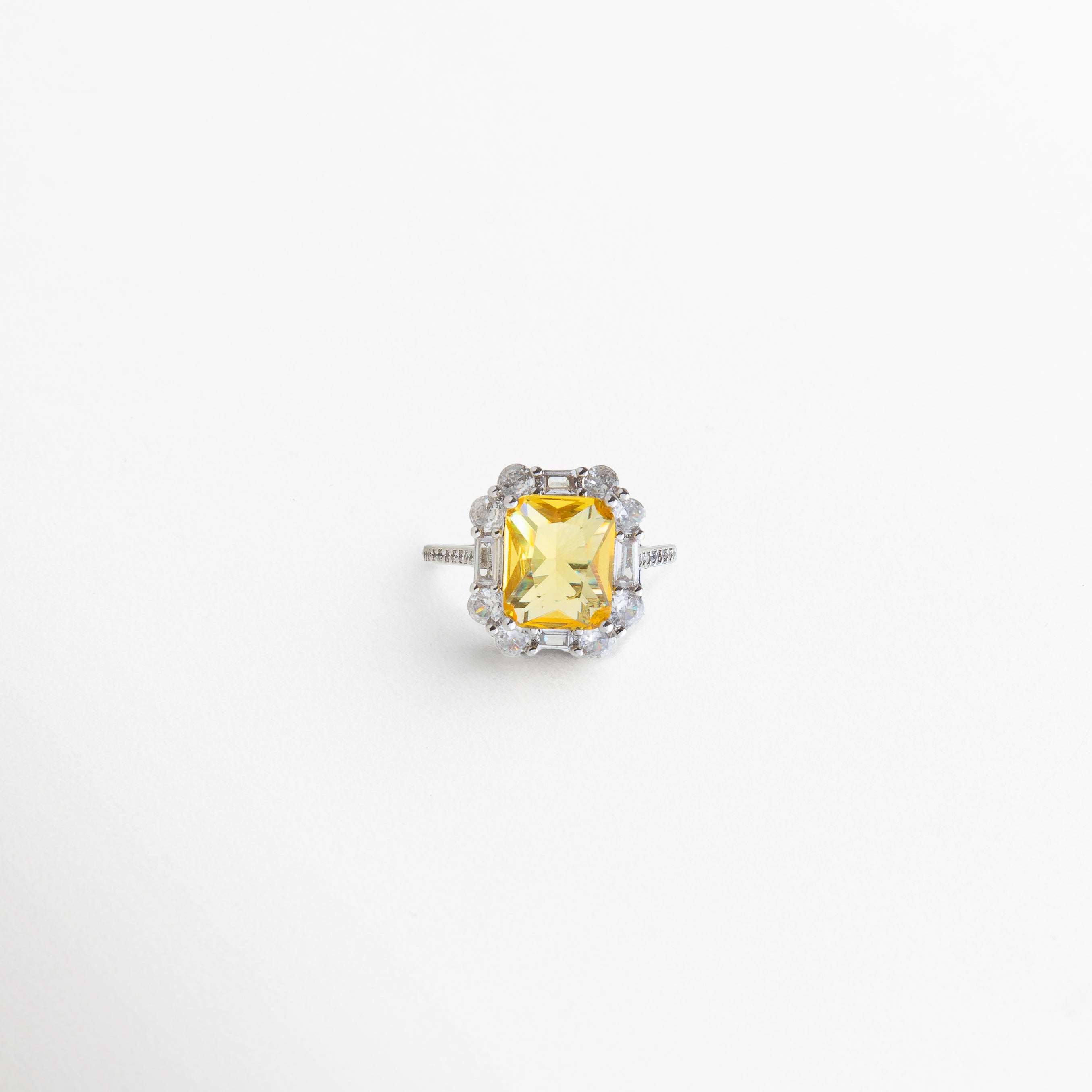 anillo en oro blanco con piedra central rodeada de halo de gemas, diseño elegante con zirconias cúbicas y diamantes de laboratorio, joya sofisticada con brillo intenso, estilo moderno con encanto atemporal, pieza ideal para ocasiones especiales