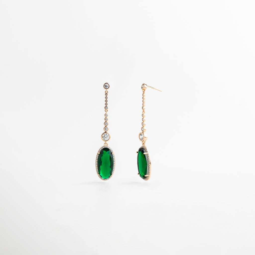 Vista completa de aretes dorados de 6 cm con piedra verde colgante y detalles brillantes, Aretes largos con base de cobre, recubrimiento dorado y piedra preciosa artificial verde, Pendientes femeninos con silueta alargada y colgante verde ovalado en acabado elegante, Aretes delicados con brillo sutil y piedra verde intensa, presentados en vista frontal, Diseño de aretes colgantes en tono oro con piedra verde y acabado sofisticado.
