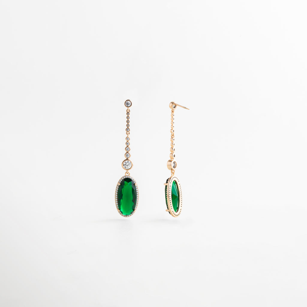 Ángulo lateral de aretes elegantes con colgante verde y detalles brillantes en tono dorado, Vista de perfil de aretes largos con piedra preciosa artificial verde y caída delicada, Pendientes dorados con diseño fino y piedra verde ovalada, vistos desde un costado, Aretes colgantes de estilo refinado con piedra verde brillante y acabado elegante, Detalle lateral de aretes largos dorados con piedra verde colgante para ocasión especial.