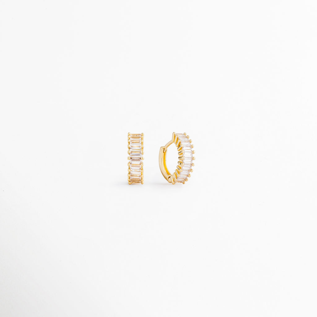 Perfil de los Isabel Golden Hoops con incrustaciones de zirconia, Vista lateral de arracadas doradas pequeñas con acabado brillante, Detalle del diseño compacto de los hoops dorados con zirconias, Aretes tipo arracada en Oro 18K vistos de perfil, Vista lateral de aretes elegantes para uso diario con zirconias.