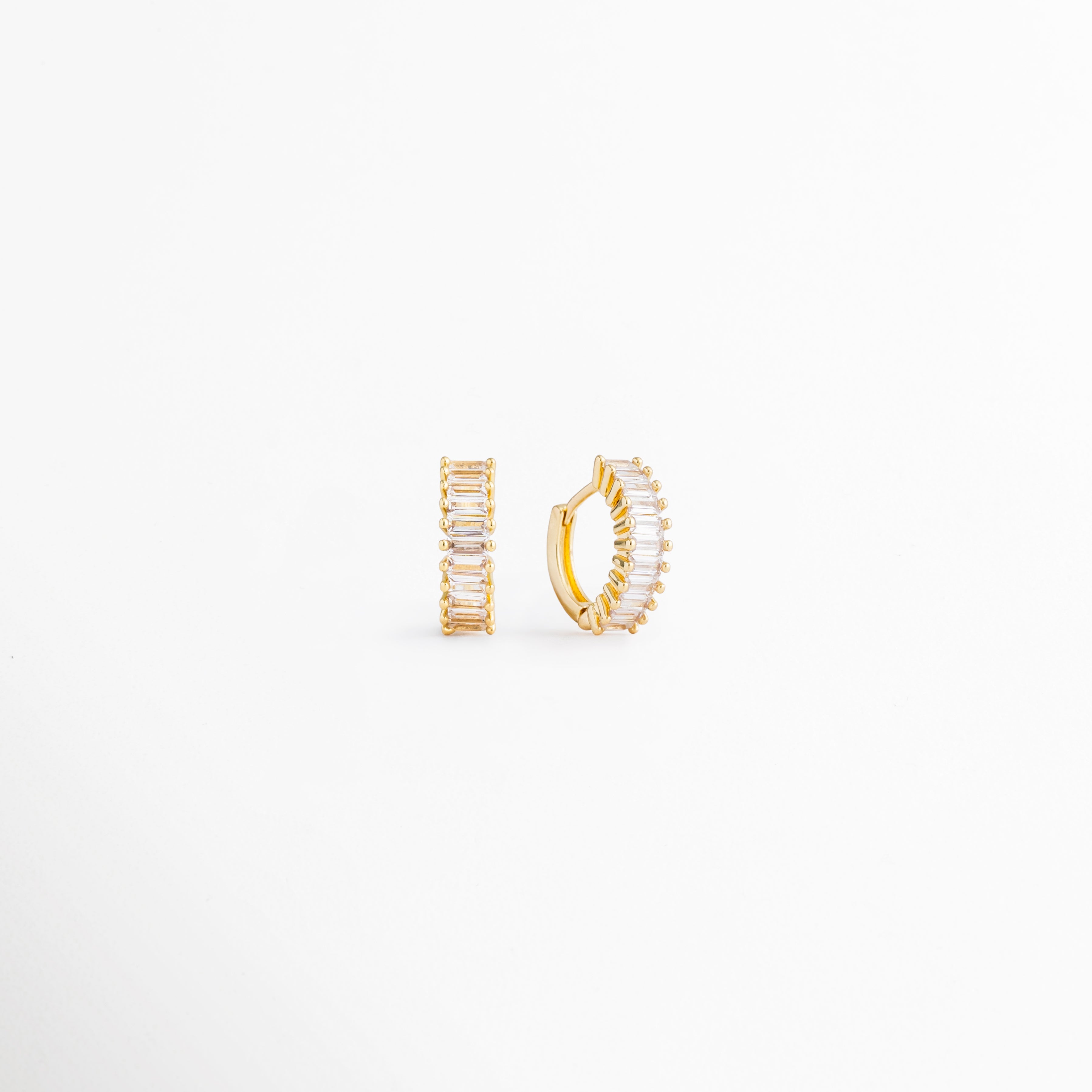Perfil de los Isabel Golden Hoops con incrustaciones de zirconia, Vista lateral de arracadas doradas pequeñas con acabado brillante, Detalle del diseño compacto de los hoops dorados con zirconias, Aretes tipo arracada en Oro 18K vistos de perfil, Vista lateral de aretes elegantes para uso diario con zirconias.