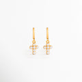 Aretes Cruz con Perlas de acero inoxidable con recubrimiento en Oro y perlas sintéticas sobre fondo blanco, Vista frontal de los Aretes Cruz con Perlas con diseño colgante en forma de cruz y acabado dorado, Aretes Cruz con Perlas con perlas sintéticas y acabado en Oro de estilo elegante, Par de Aretes Cruz con Perlas elaborados en acero inoxidable con diseño colgante y perlas, Aretes dorados con cruz de perlas sintéticas y diseño femenino para mujer.