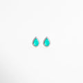 Aretes tipo gota en plata 925 con piedra turquesa y halo de diamantes sintéticos, Pendientes pequeños de plata con diseño de lágrima y cristales brillantes alrededor, Aretes elegantes color turquesa con incrustaciones de diamantes sintéticos en plata, Joyería fina con aretes de gota turquesa y acabado brillante en plata enchapada, Aretes delicados de plata ley 925 con piedra azul verdosa y detalles brillantes.