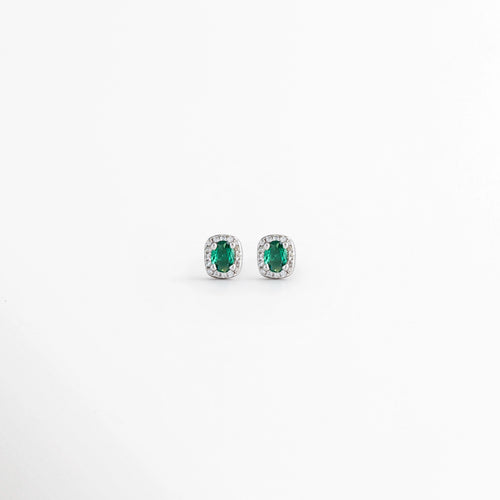 Aretes Alana Studs de Plata Ley 925 con esmeralda sintética ovalada y zirconias en acabado de Plata Esterlina, Vista frontal de los Aretes Alana Studs con esmeralda sintética verde rodeada de zirconias, Aretes Alana Studs de plata con esmeralda sintética y zirconias en diseño clásico y elegante, Par de Aretes Alana Studs con piedra verde ovalada y acabado en Plata Esterlina sobre fondo blanco, Aretes Alana Studs elaborados en Plata Ley 925 con esmeralda sintética y zirconias brillantes.