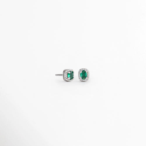 Vista en ángulo de los Aretes Alana Studs con esmeralda sintética y zirconias sobre Plata Ley 925, Perspectiva de los Aretes Alana Studs que resalta el brillo de la esmeralda sintética verde, Aretes Alana Studs fotografiados en ángulo mostrando la montura de Plata Esterlina, Vista diagonal de los Aretes Alana Studs con piedra verde ovalada y zirconias, Aretes de Plata Ley 925 Alana Studs con esmeralda sintética en vista de perspectiva.