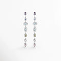 Aretes Silver Roux de 6.5 cm con secuencia vertical de piedras multicolores de cortes variados enchapados en oro blanco 18K, vista frontal sobre fondo blanco, Vista de frente de aretes largos colgantes con gemas de tonos lavanda, azul, celeste, verde oliva y rosa engastadas en plata, Par de aretes largos y fluidos con gemas sintéticas multicolores de corte ovalado, gota, bisel y marquesa, Aretes de fiesta de 6.5 cm con piedras de colores pastel enmarcadas en biseles