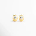 Aretes Piaf Hoops de cobre con recubrimiento en Oro 18K y zirconia central sobre fondo blanco, Vista frontal de los Aretes Piaf Hoops con diseño ovalado y zirconia brillante en acabado Oro 18K, Aretes Piaf Hoops con diseño elegante de aro ovalado y zirconia central, Par de Aretes Piaf Hoops con acabado en Oro 18K y piedra de zirconia, Aretes dorados Piaf Hoops con diseño minimalista y zirconia brillante.
