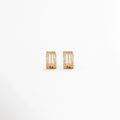 Aretes Jovovich Golden Hoops de cobre con recubrimiento en Oro y diseño tipo huggie con textura sobre fondo blanco, Vista frontal de los Aretes Jovovich Golden Hoops con acabado dorado brillante y diseño minimalista, Aretes Jovovich Golden Hoops con diseño de aro pequeño y textura elegante en acabado dorado, Par de Aretes Jovovich Golden Hoops elaborados en cobre con recubrimiento en Oro, Aretes dorados Jovovich Golden Hoops con diseño moderno tipo huggie y acabado brillante.