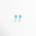 Aretes Boreal Blue de plata con acabado en Oro Blanco 18K, piedra preciosa marina azul y perla blanca sobre fondo blanco, Vista frontal de los Aretes Boreal Blue con piedra azul marina, perla blanca y diseño elegante de plata, Aretes Boreal Blue con piedra preciosa marina ovalada y perla blanca, elaborados en plata con recubrimiento de Oro Blanco 18K, Par de Aretes Boreal Blue con diseño minimalista, piedra azul y perla blanca en acabado de Oro Blanco 18K, Aretes de plata Boreal Blue con piedra azul marina