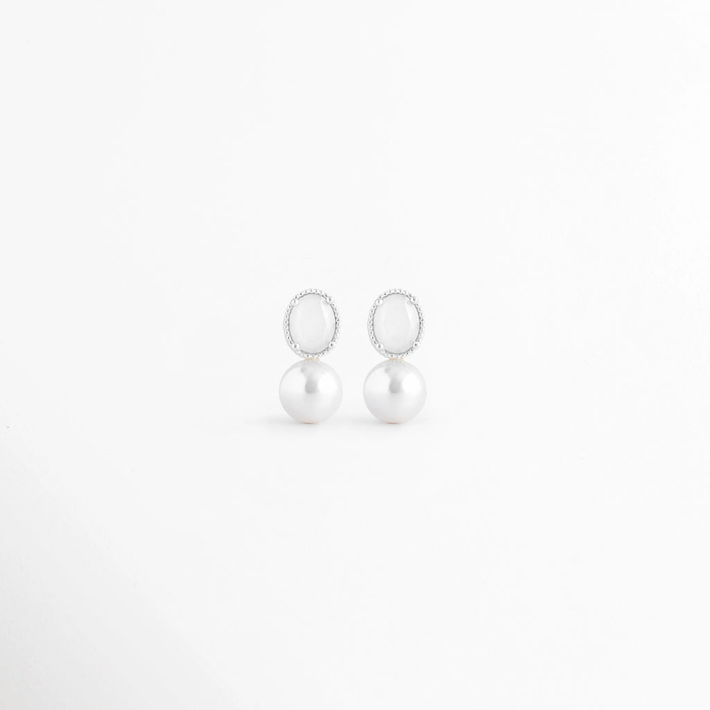 Aretes Boreal White de plata con acabado en Oro Blanco 18K, piedra preciosa marina blanca y diseño elegante sobre fondo blanco, Vista frontal de los Aretes Boreal White con piedra preciosa marina blanca y acabado en Oro Blanco 18K, Aretes Boreal White elaborados en plata con piedra blanca y diseño minimalista para mujer, Aretes Boreal White con piedra preciosa marina blanca y recubrimiento en Oro Blanco 18K en vista frontal, Par de Aretes Boreal White de plata con piedra blanca y acabado brillante de Oro