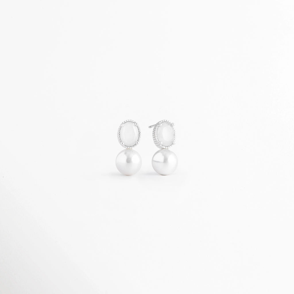Vista en ángulo de los Aretes Boreal White con piedra preciosa marina blanca y acabado en Oro Blanco 18K,Perspectiva de los Aretes Boreal White que resalta el brillo de la piedra blanca y su diseño elegante, Aretes Boreal White fotografiados en ángulo mostrando la piedra blanca y el acabado en Oro Blanco 18K, Vista diagonal de los Aretes Boreal White de plata con piedra preciosa marina blanca, Aretes Boreal White con diseño minimalista en perspectiva sobre fondo blanco.