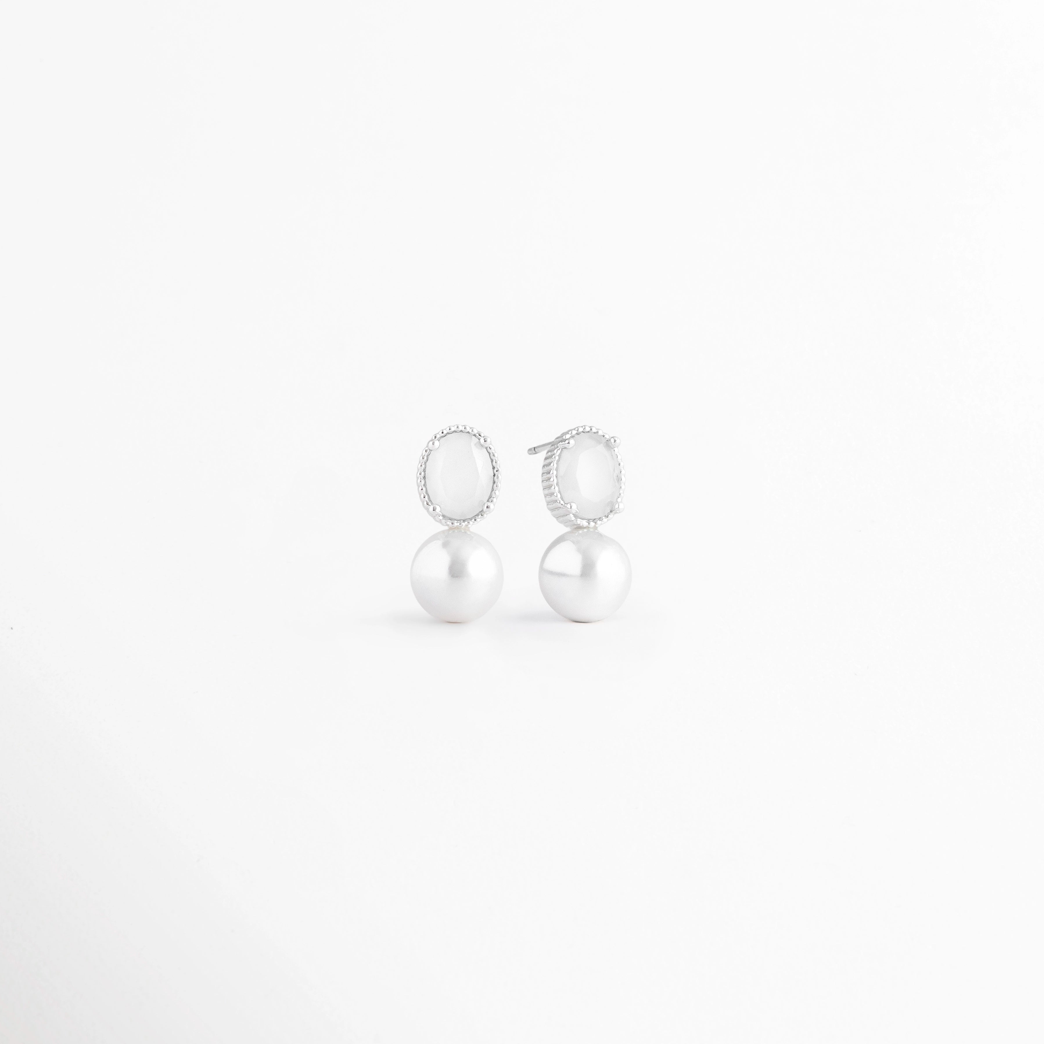 Vista en ángulo de los Aretes Boreal White con piedra preciosa marina blanca y acabado en Oro Blanco 18K,Perspectiva de los Aretes Boreal White que resalta el brillo de la piedra blanca y su diseño elegante, Aretes Boreal White fotografiados en ángulo mostrando la piedra blanca y el acabado en Oro Blanco 18K, Vista diagonal de los Aretes Boreal White de plata con piedra preciosa marina blanca, Aretes Boreal White con diseño minimalista en perspectiva sobre fondo blanco.