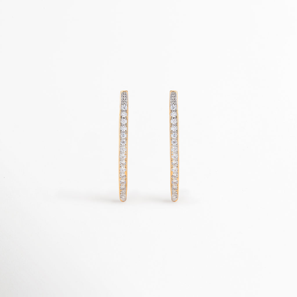 Aretes Regina largos con zirconias y acabado dorado elegante, Aretes dorados lineales con incrustaciones de zirconia para mujer, Aretes Regina de diseño estilizado con brillo sofisticado, Aretes largos dorados con zirconias y silueta moderna, Aretes elegantes tipo barra con acabado en oro y detalles brillantes