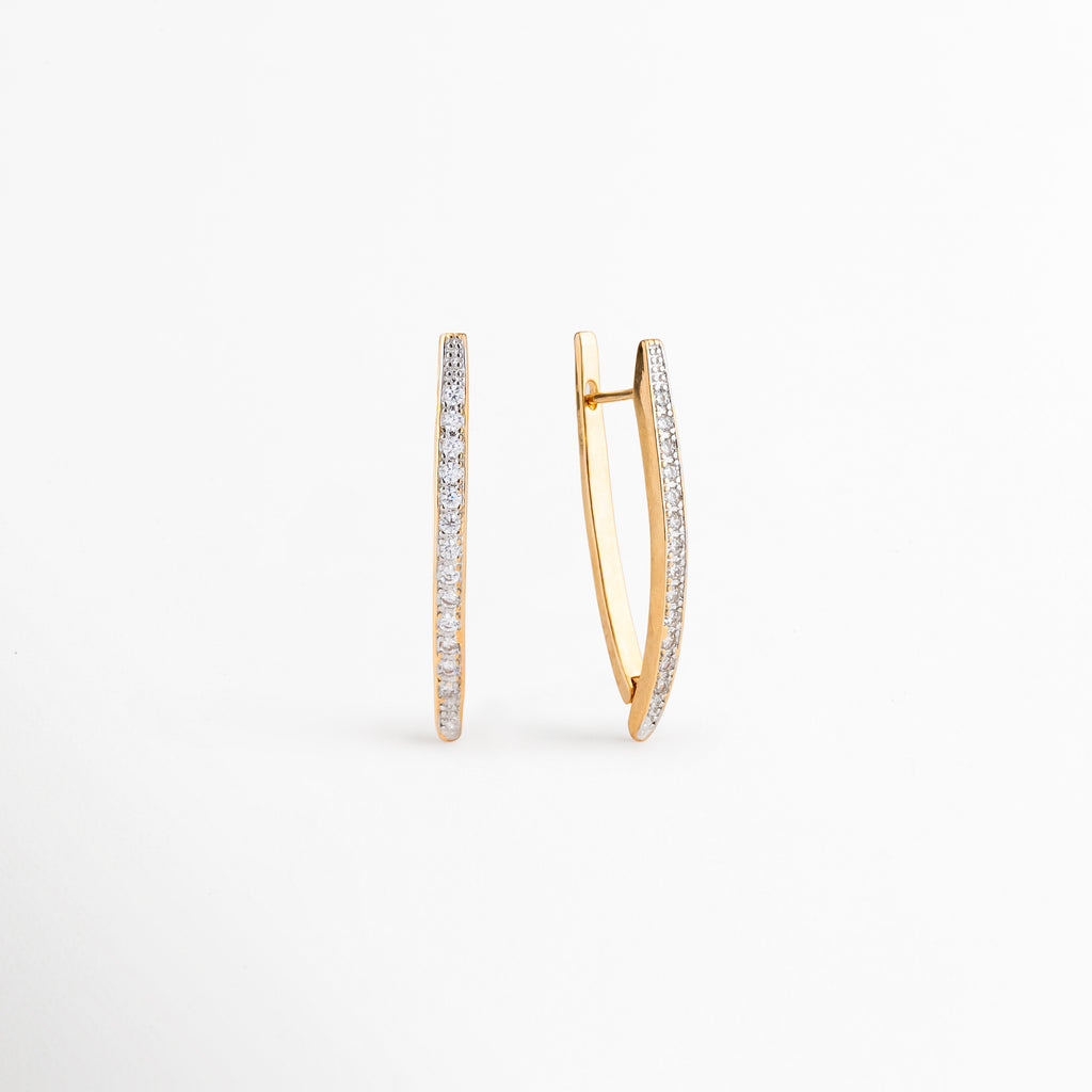 Perfil de los Aretes Regina con zirconias incrustadas y acabado dorado, Vista lateral de aretes largos elegantes con diseño contemporáneo, Detalle del cierre y estructura de los Aretes Regina, Aretes dorados con zirconias vistos de perfil, Vista lateral de aretes sofisticados con silueta estilizada.