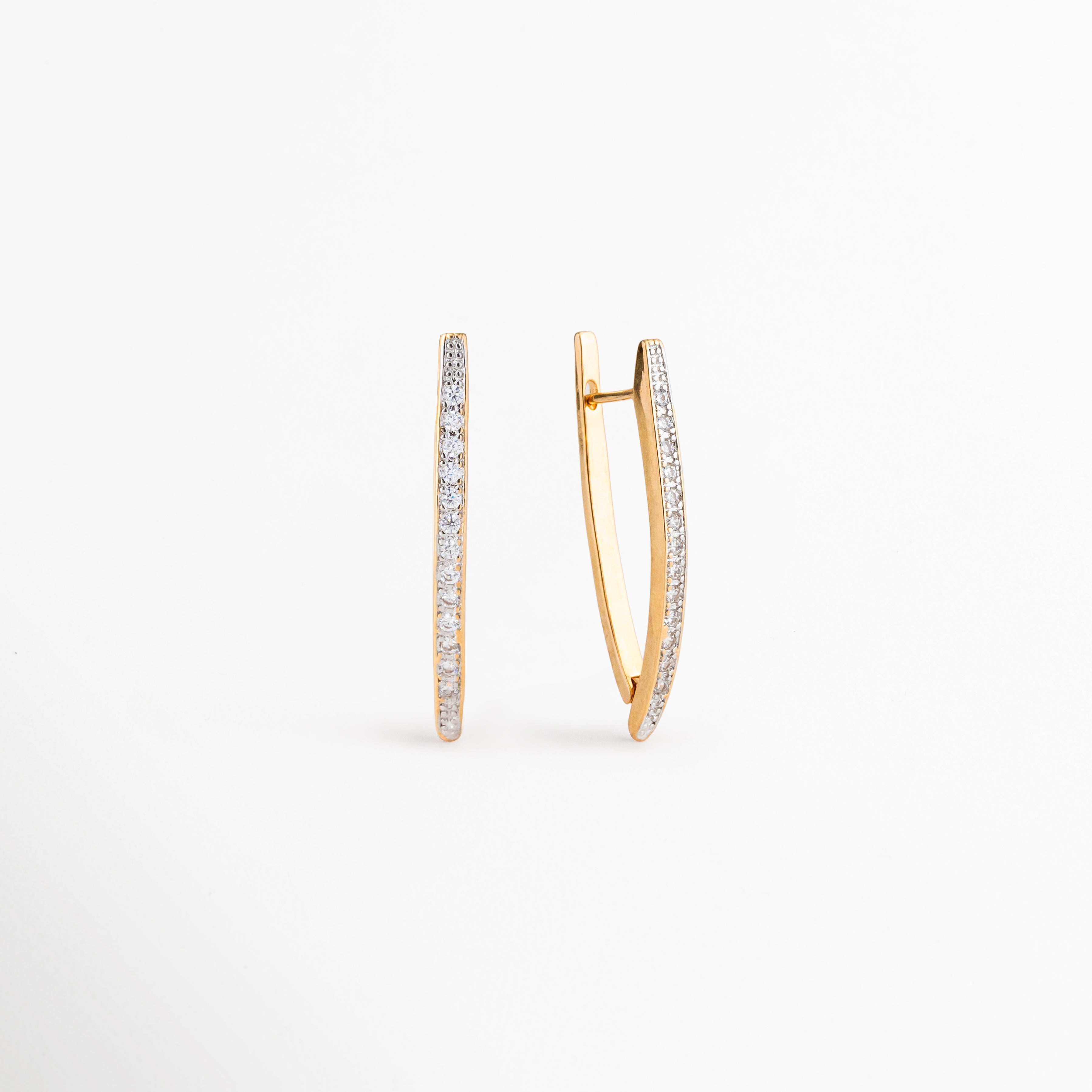 Perfil de los Aretes Regina con zirconias incrustadas y acabado dorado, Vista lateral de aretes largos elegantes con diseño contemporáneo, Detalle del cierre y estructura de los Aretes Regina, Aretes dorados con zirconias vistos de perfil, Vista lateral de aretes sofisticados con silueta estilizada.