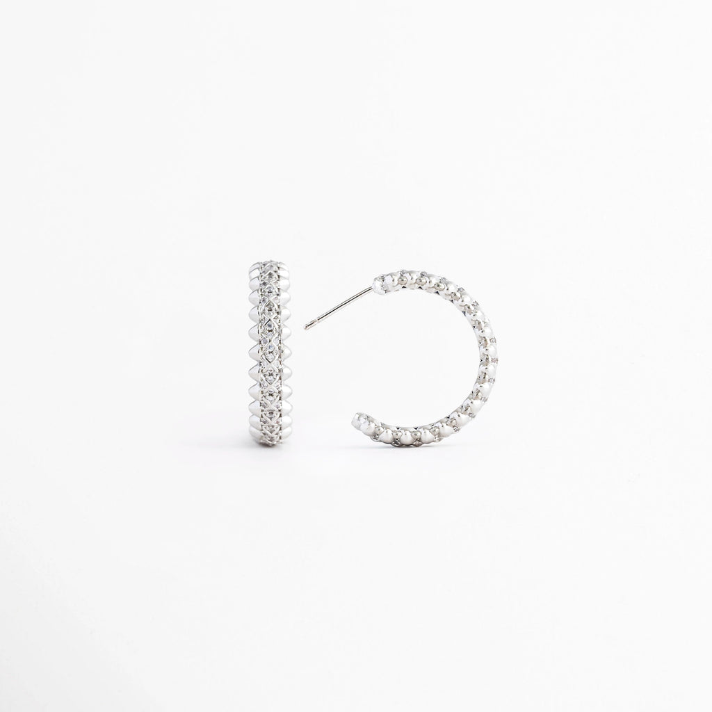 Vista lateral de los Aretes Silver Azira mostrando el broche tipo poste y el grosor de la barra, Perfil de los Aretes Silver Azira con acabado en Oro Blanco e incrustaciones de zirconias, Aretes Silver Azira en vista lateral destacando el sistema de cierre y su diseño minimalista, Detalle lateral de los Aretes Silver Azira elaborados en aleación metálica, Vista de costado de los Aretes Silver Azira con acabado plateado brillante.