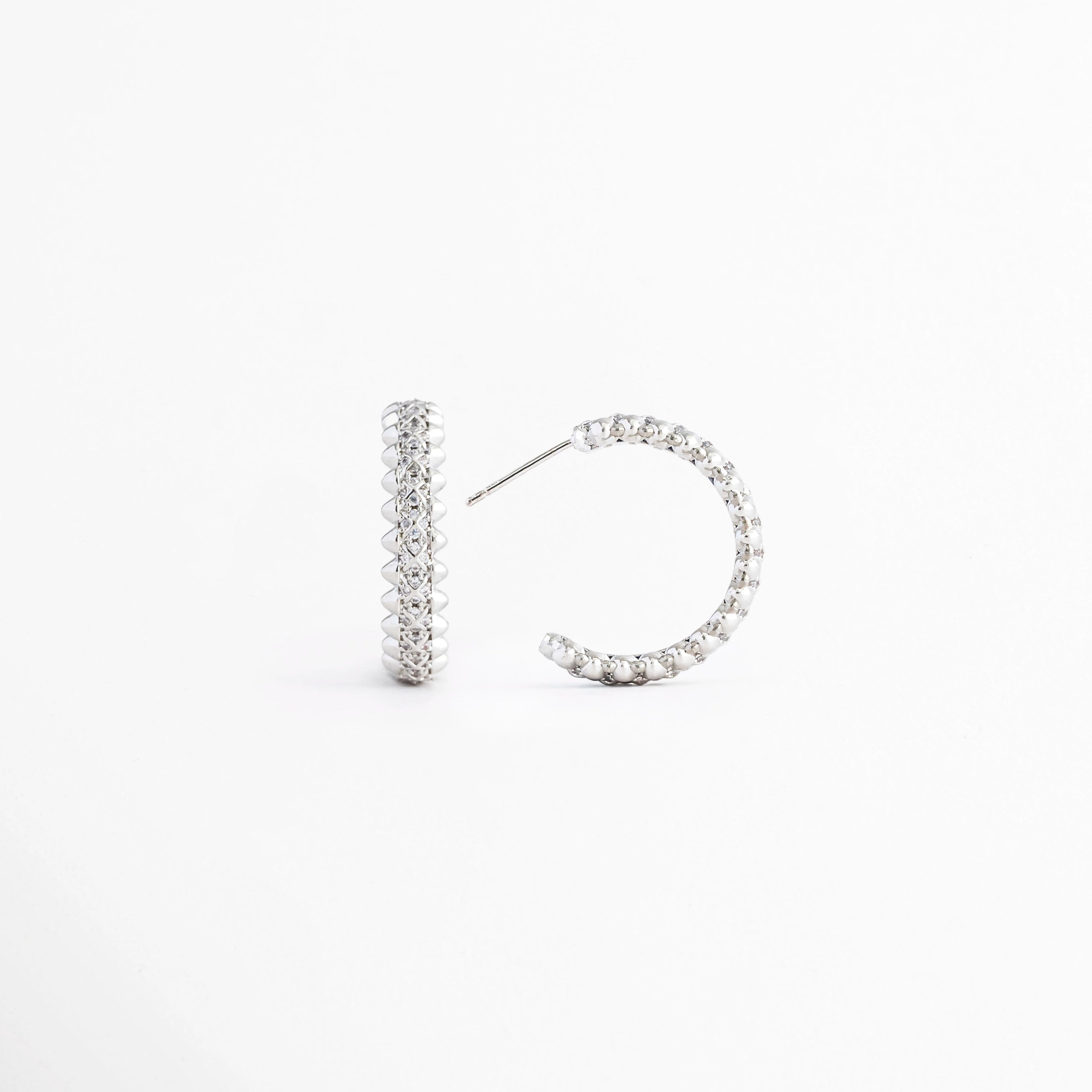 Vista lateral de los Aretes Silver Azira mostrando el broche tipo poste y el grosor de la barra, Perfil de los Aretes Silver Azira con acabado en Oro Blanco e incrustaciones de zirconias, Aretes Silver Azira en vista lateral destacando el sistema de cierre y su diseño minimalista, Detalle lateral de los Aretes Silver Azira elaborados en aleación metálica, Vista de costado de los Aretes Silver Azira con acabado plateado brillante.