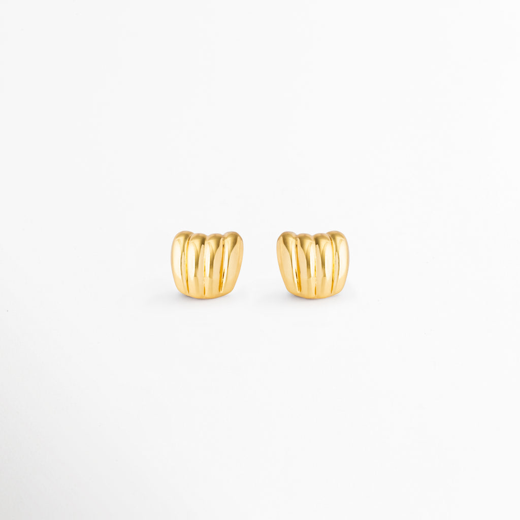 Aretes Aurelia Studs dorados con diseño moderno de líneas curvas en acero inoxidable, Aretes pequeños Aurelia Studs con baño de oro 18K y estilo minimalista. Par de aretes dorados elegantes con textura acanalada y acabado brillante, Aretes tipo stud de acero inoxidable enchapados en oro 18K para mujer, Aurelia Studs de diseño contemporáneo, ideales para looks diarios y sofisticados.