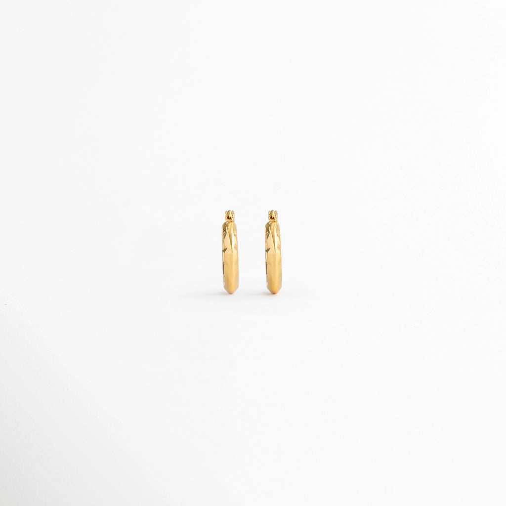 Vista posterior de los Aretes Doré Hoops mostrando el cierre tipo bisagra y el acabado en Oro 18K, Parte trasera de los Aretes Doré Hoops con sistema de cierre tipo huggie y acabado dorado, Aretes Doré Hoops en vista posterior destacando la estructura del aro y el mecanismo de cierre, Detalle de la parte posterior de los Aretes Doré Hoops elaborados en acero inoxidable, Vista trasera de los Aretes Doré Hoops con diseño clásico y cierre seguro.