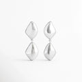 Aretes Bastet de aleación de metales con acabado plateado brillante y diseño geométrico colgante sobre fondo blanco, Vista frontal de los Aretes Bastet con figuras geométricas de acabado pulido y estilo contemporáneo, Aretes Bastet con diseño colgante de formas geométricas y acabado electro-chapado brillante, Par de Aretes Bastet con diseño moderno de doble pieza geométrica en color plateado, Aretes Bastet de estilo contemporáneo con acabado brillante y diseño geométrico alargado