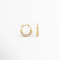 Vista lateral de los Aretes Lotus Hoops con zirconias incrustadas, Perfil de arracadas doradas con acabado brillante y diseño moderno, Detalle lateral de aretes tipo hoop con cierre seguro y zirconias, Aretes dorados para mujer con estructura ligera y elegante, Vista de perfil de Lotus Hoops con detalles de zirconia y acabado refinado.
