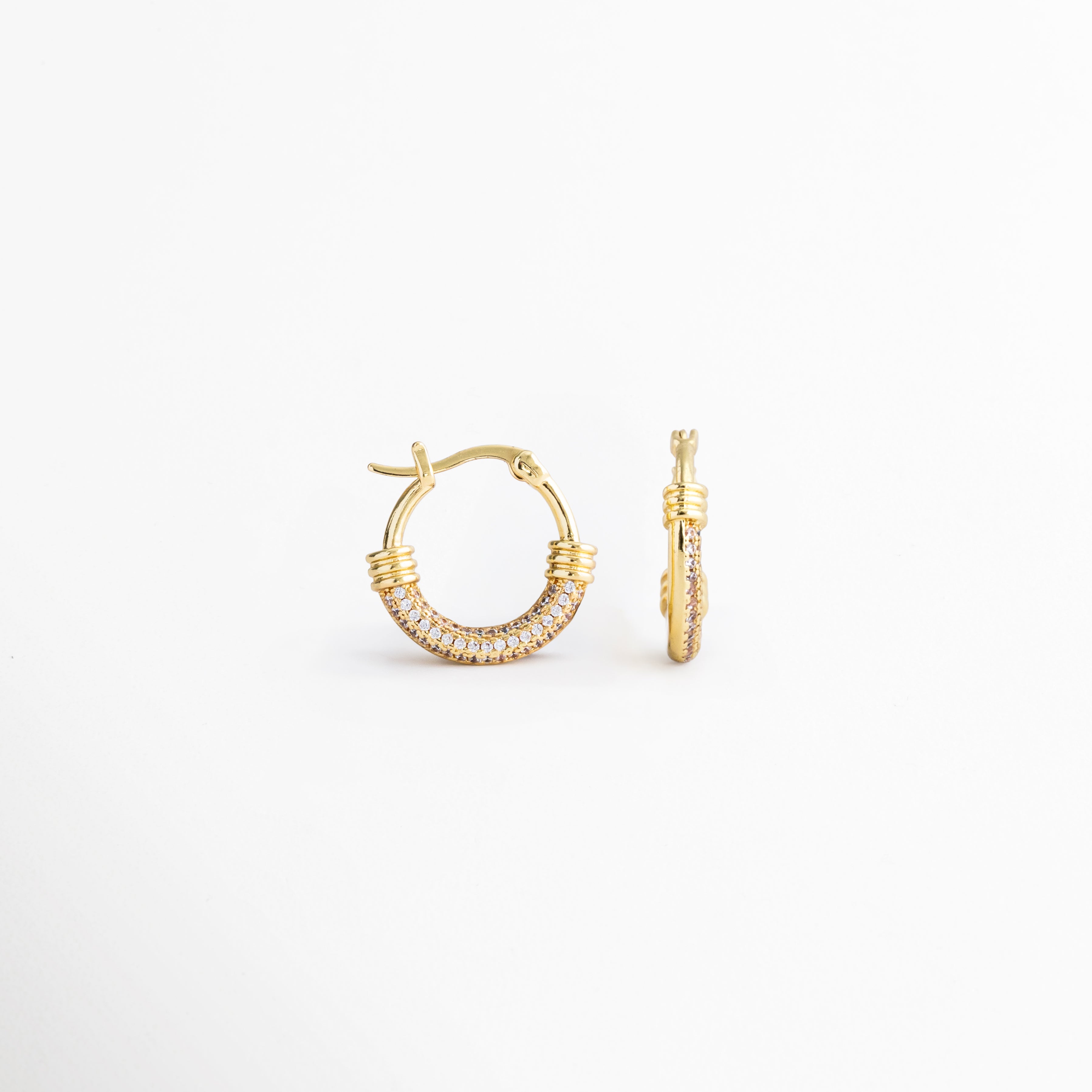 Vista lateral de los Aretes Lotus Hoops con zirconias incrustadas, Perfil de arracadas doradas con acabado brillante y diseño moderno, Detalle lateral de aretes tipo hoop con cierre seguro y zirconias, Aretes dorados para mujer con estructura ligera y elegante, Vista de perfil de Lotus Hoops con detalles de zirconia y acabado refinado.