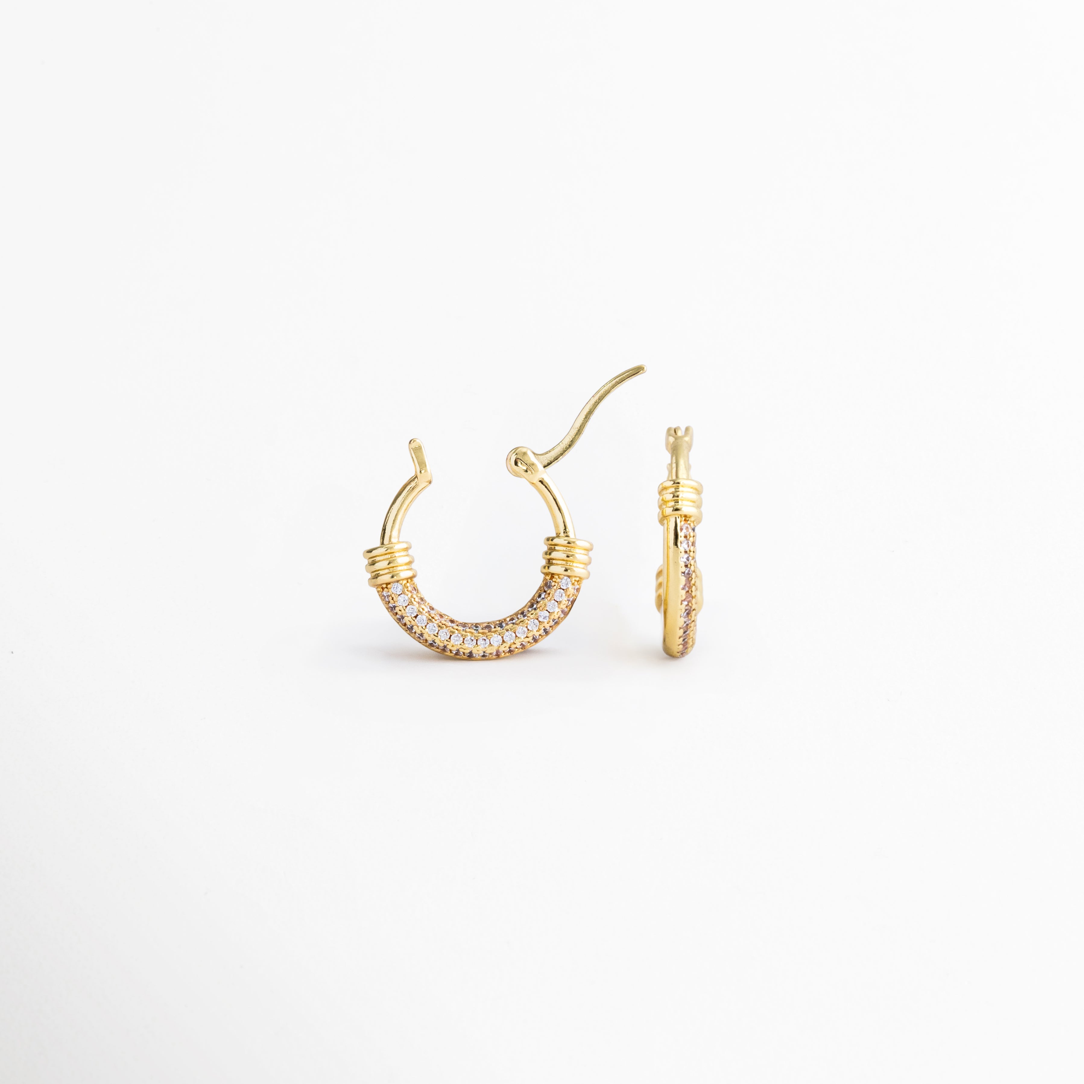 Detalle de los Aretes Lotus Hoops con incrustaciones de zirconia brillante, Vista cercana de arracadas doradas con diseño sofisticado y femenino, Aretes tipo hoop enchapados en oro con detalles luminosos de zirconia, Lotus Hoops con acabado dorado y estética moderna de inspiración minimalista, Detalle de aretes elegantes para mujer con brillo sutil y versátil.