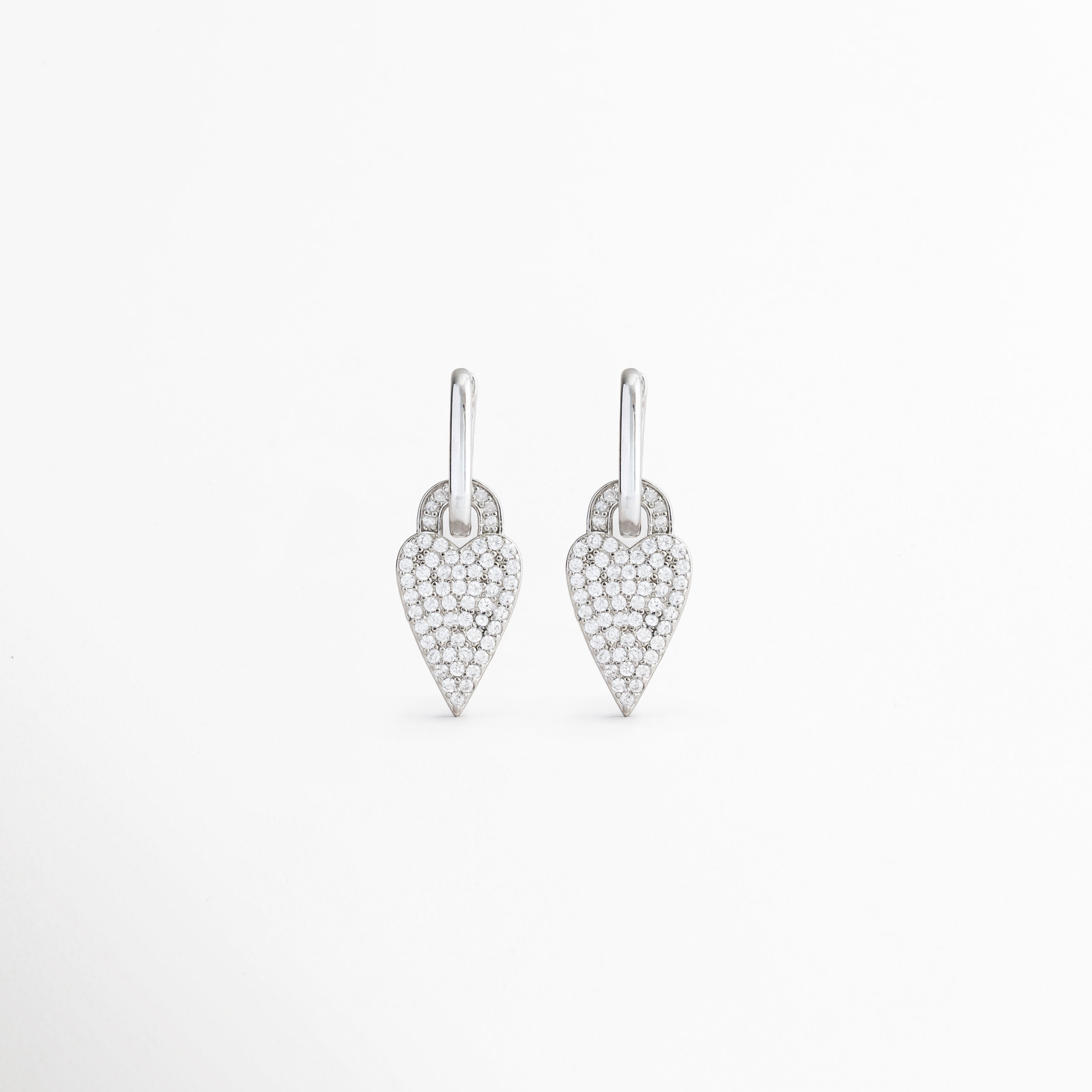 Aretes Silver Velvet Hoops con charm de corazón y zirconias brillantes, Pendientes plateados con dije de corazón y acabado en oro blanco, Aretes tipo hoop con corazón decorado con zirconias, Aretes elegantes con charm de corazón y brillo sutil, Pendientes Silver Velvet Hoops de estilo femenino y moderno.