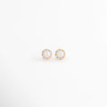 Aretes Zerina Golden Studs de Plata de Ley 925 con recubrimiento en Oro 14K y zirconia brillante sobre fondo blanco, Vista frontal de los Aretes Zerina Golden Studs con zirconia central rodeada de un delicado halo brillante, Aretes Zerina Golden Studs con diseño redondo, zirconia y acabado en Oro 14K, Par de Aretes Zerina Golden Studs elaborados en Plata de Ley 925 con zirconia y acabado dorado, Aretes dorados Zerina Golden Studs con zirconia en diseño clásico y elegante.