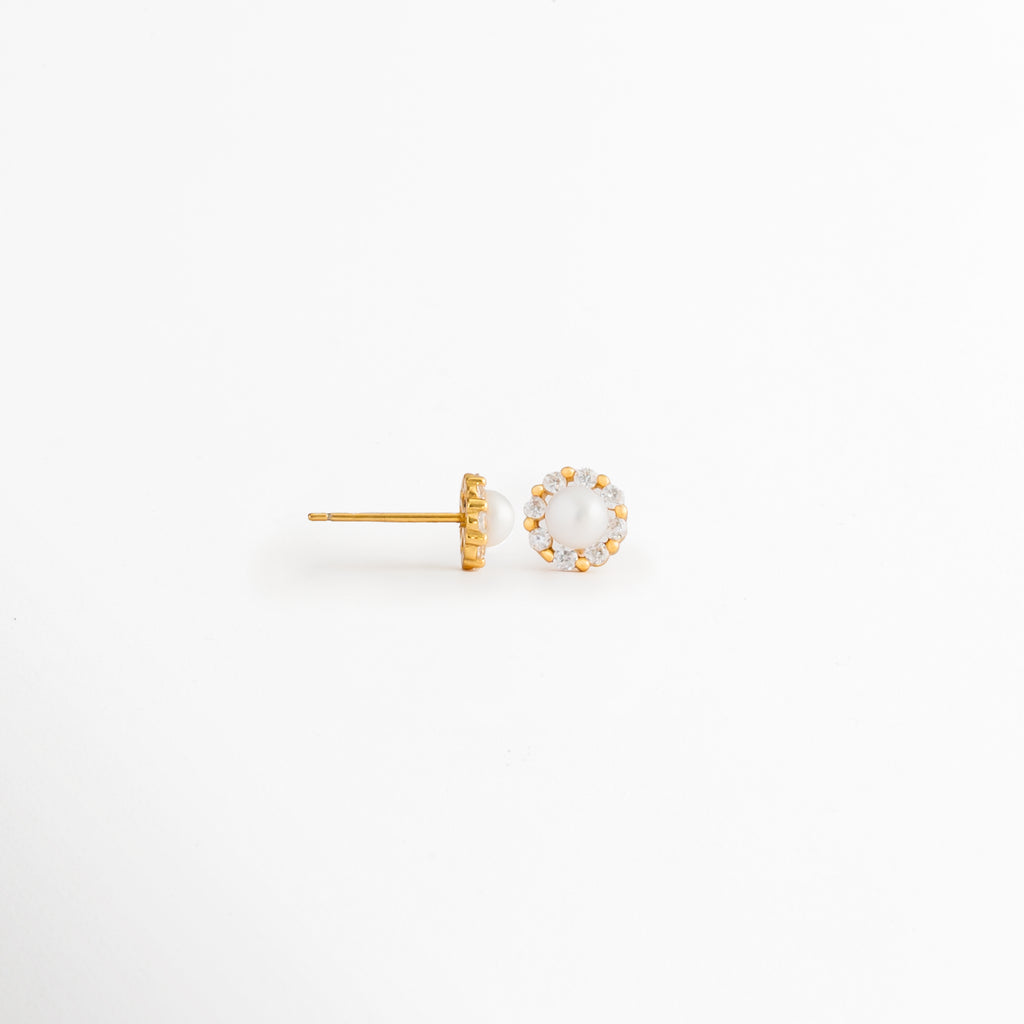 Vista lateral de los Aretes Zerina Golden Studs mostrando el broche tipo poste y la montura de la zirconia, Perfil de los Aretes Zerina Golden Studs con acabado en Oro 14K y piedra de zirconia, Aretes Zerina Golden Studs en vista lateral destacando el sistema de cierre y el grosor de la montura, Detalle lateral de los Aretes Zerina Golden Studs elaborados en Plata de Ley 925, Vista de costado de los Aretes Zerina Golden Studs con zirconia y acabado dorado brillante.