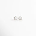 Aretes Zerina Silver Studs de Plata de Ley 925 con recubrimiento en Oro Blanco 14K y zirconia brillante sobre fondo blanco, Vista frontal de los Aretes Zerina Silver Studs con zirconia central rodeada por un delicado halo brillante, Aretes Zerina Silver Studs con diseño redondo y zirconia en acabado de Oro Blanco 14K, Par de Aretes Zerina Silver Studs elaborados en Plata de Ley 925 con zirconia y acabado plateado brillante, Aretes plateados Zerina Silver Studs con zirconia en diseño clásico y elegante.