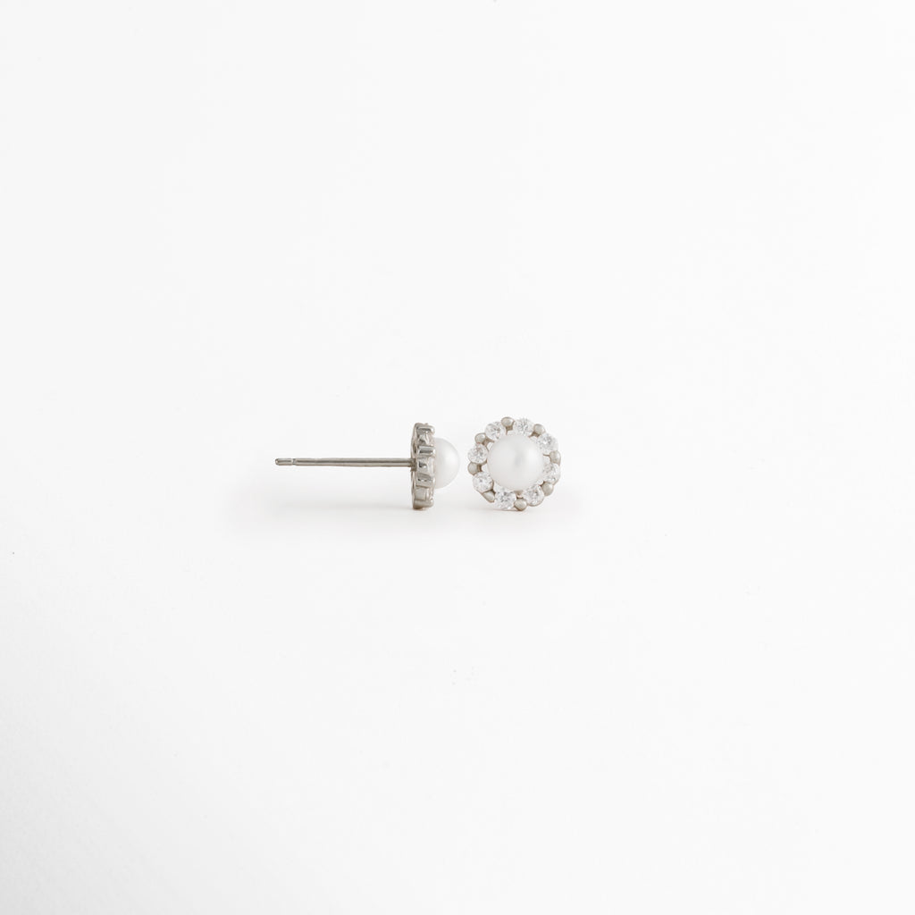 Vista lateral de los Aretes Zerina Silver Studs mostrando el broche tipo poste y la montura de la zirconia, Perfil de los Aretes Zerina Silver Studs con acabado en Oro Blanco 14K y piedra de zirconia, Aretes Zerina Silver Studs en vista lateral destacando el sistema de cierre y el grosor de la montura, Detalle lateral de los Aretes Zerina Silver Studs elaborados en Plata de Ley 925, Vista de costado de los Aretes Zerina Silver Studs con zirconia y acabado plateado brillante.
