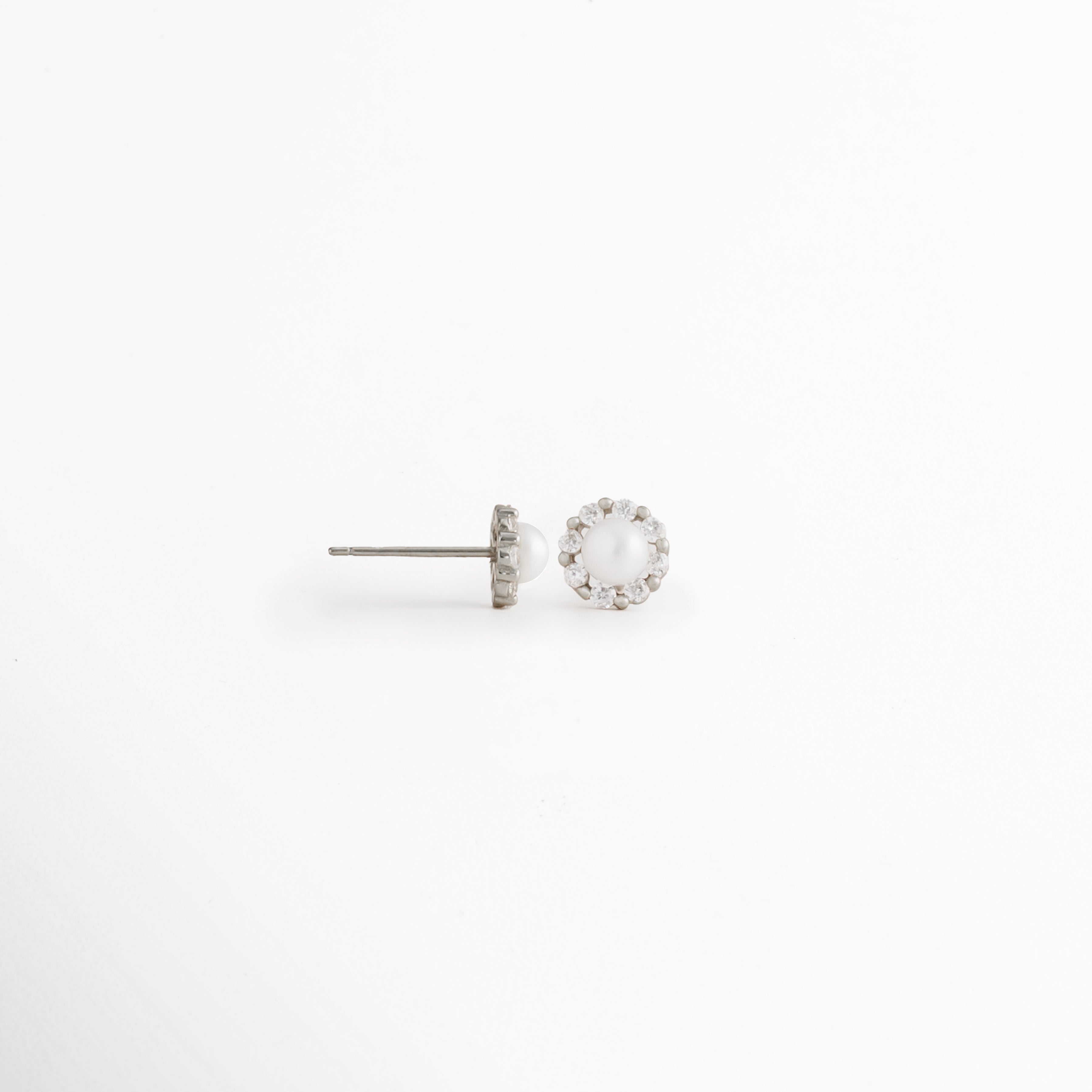 Vista lateral de los Aretes Zerina Silver Studs mostrando el broche tipo poste y la montura de la zirconia, Perfil de los Aretes Zerina Silver Studs con acabado en Oro Blanco 14K y piedra de zirconia, Aretes Zerina Silver Studs en vista lateral destacando el sistema de cierre y el grosor de la montura, Detalle lateral de los Aretes Zerina Silver Studs elaborados en Plata de Ley 925, Vista de costado de los Aretes Zerina Silver Studs con zirconia y acabado plateado brillante.