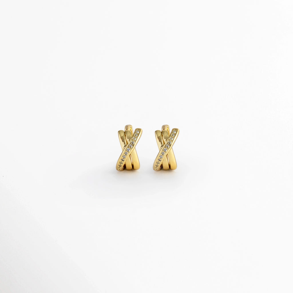 Aretes Diana Golden Hoops de 1.1 cm con diseño de tres aros entrelazados en forma de X e incrustación de circonias en la banda diagonal, vista frontal sobre fondo blanco, Vista de frente de micro huggies dorados enchapados en oro con tres tiras cruzadas y pavé de pedrería fina, Par de aros huggie compactos de 1.1 x 0.6 cm con diseño entrelazado y detalles de circonias brillantes, Aretes entrelazados dorados estilo bandas cruzadas con circonias transparentes sobre fondo