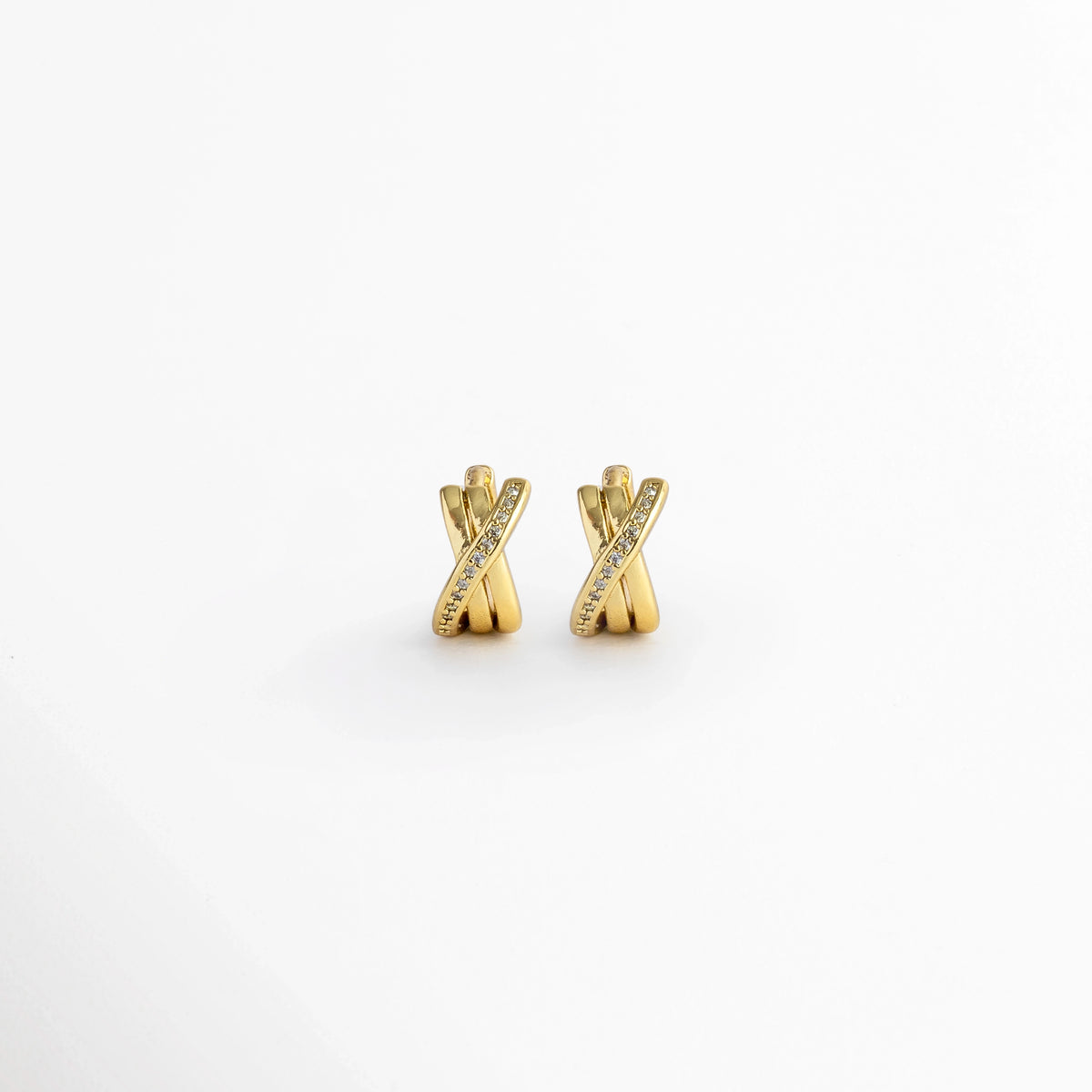 Aretes Diana Golden Hoops de 1.1 cm con diseño de tres aros entrelazados en forma de X e incrustación de circonias en la banda diagonal, vista frontal sobre fondo blanco, Vista de frente de micro huggies dorados enchapados en oro con tres tiras cruzadas y pavé de pedrería fina, Par de aros huggie compactos de 1.1 x 0.6 cm con diseño entrelazado y detalles de circonias brillantes, Aretes entrelazados dorados estilo bandas cruzadas con circonias transparentes sobre fondo