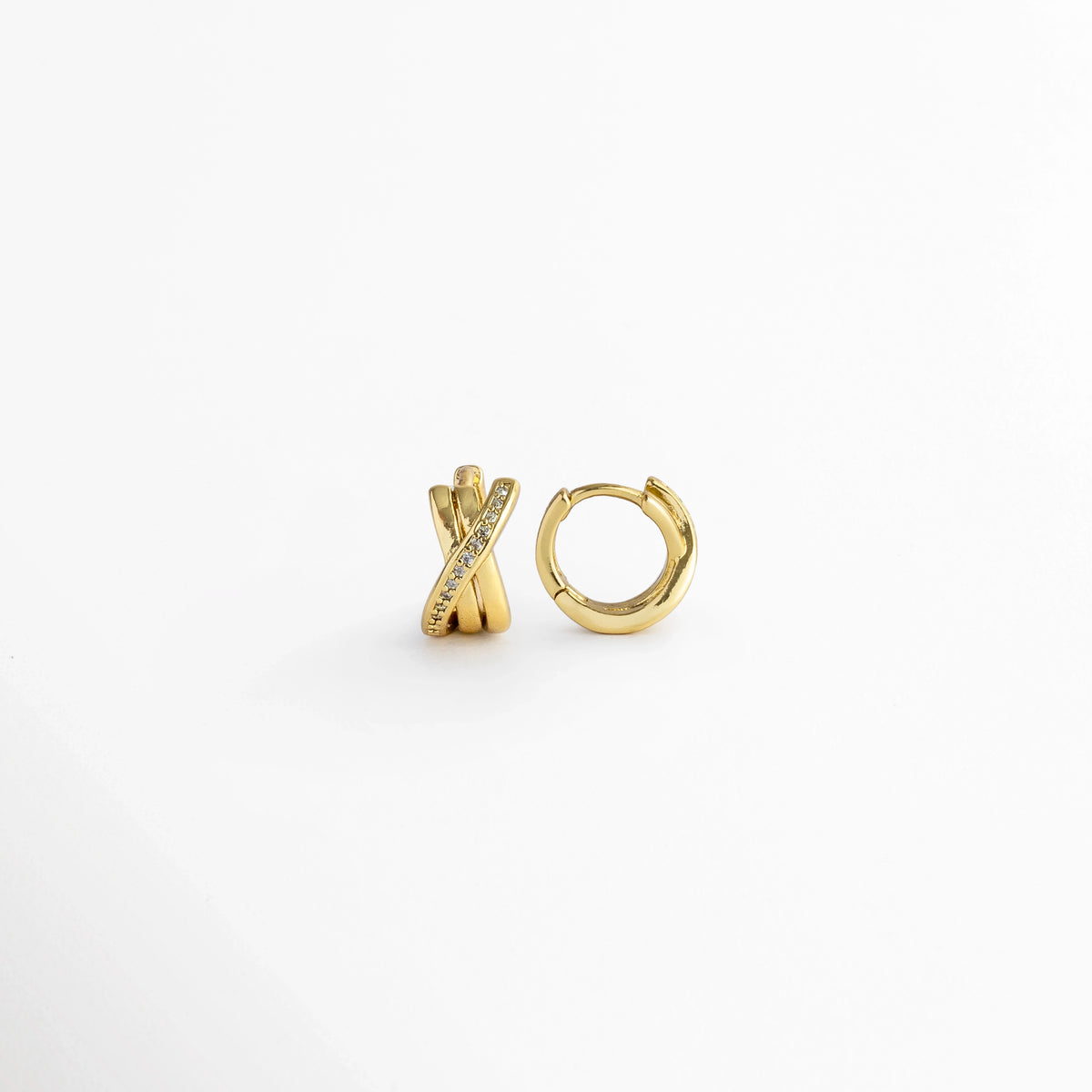 Vista lateral de los Diana Golden Hoops cerrados mostrando la bisagra posterior y el ajuste de poste continuo, Detalle del cierre tipo click/snap en el perfil arqueado de los aros dorados entrelazados de 1.1 cm, Muestra de perfil del grosor de 0.6 cm y las tres bandas doradas superpuestas con circonias, Acercamiento lateral al acabado enchapado en oro de alta precisión en la estructura del huggie.
