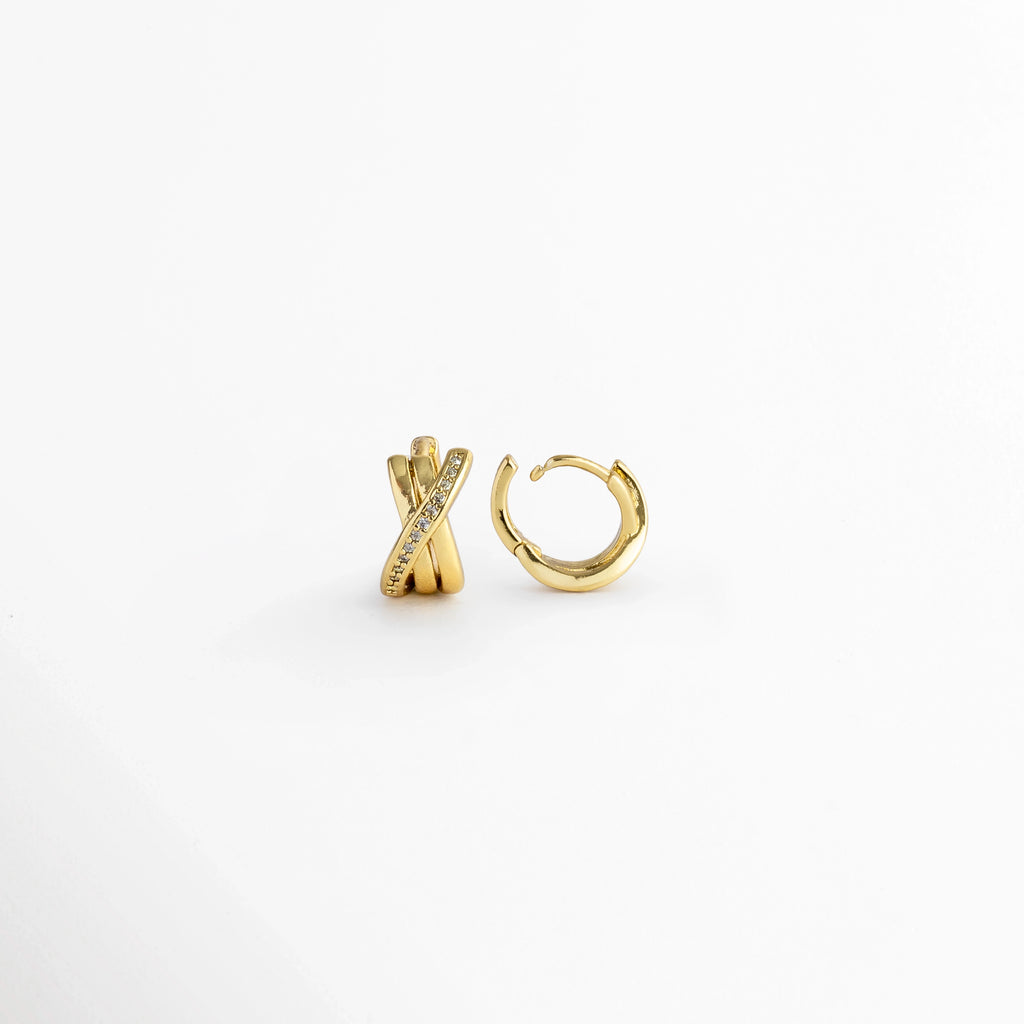 Vista lateral de los Diana Golden Hoops con la bisagra articulada completamente abierta para mostrar el poste de ajuste, Acercamiento al sistema de apertura y bisagra fácil del micro aro entrelazado dorado de 1.1 cm, Detalle del poste delgado para oreja perforada en los aretes cruzados con circonias, Muestra de la precisión del broche de bisagra en los aros dorados de tres bandas entrelazadas.