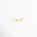 Aretes Golden Zerald de cobre con recubrimiento en Oro e incrustaciones de zirconias sobre fondo blanco, Vista frontal de los Aretes Golden Zerald con diseño curvo y zirconias brillantes, Aretes Golden Zerald con diseño minimalista curvo y acabado en Oro, Par de Aretes Golden Zerald con zirconias incrustadas y acabado dorado brillante, Aretes Golden Zerald con diseño elegante de líneas curvas y zirconias.