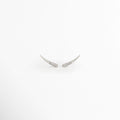 Aretes Silver Zerald de cobre con recubrimiento en Oro Blanco e incrustaciones de zirconias sobre fondo blanco, Vista frontal de los Aretes Silver Zerald con diseño curvo y zirconias brillantes, Aretes Silver Zerald con diseño minimalista curvo y acabado en Oro Blanco, Par de Aretes Silver Zerald con zirconias incrustadas y acabado plateado brillante, Aretes Silver Zerald con diseño elegante de líneas curvas y zirconias.