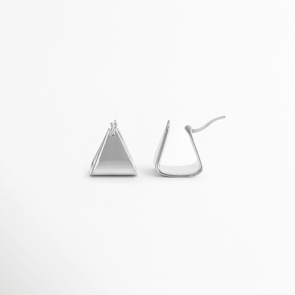 Parte trasera de los aretes Silver Corot mostrando su sistema de cierre seguro y cómodo, Vista posterior de pendientes triangulares Silver Corot con acabado pulido en tono plata, Detalle del broche de los aretes Silver Corot, diseñados para un ajuste práctico y ligero, Aretes geométricos Silver Corot vistos desde atrás, resaltando su construcción sencilla y funcional, Cierre posterior de los aretes Silver Corot con diseño minimalista para uso diario.