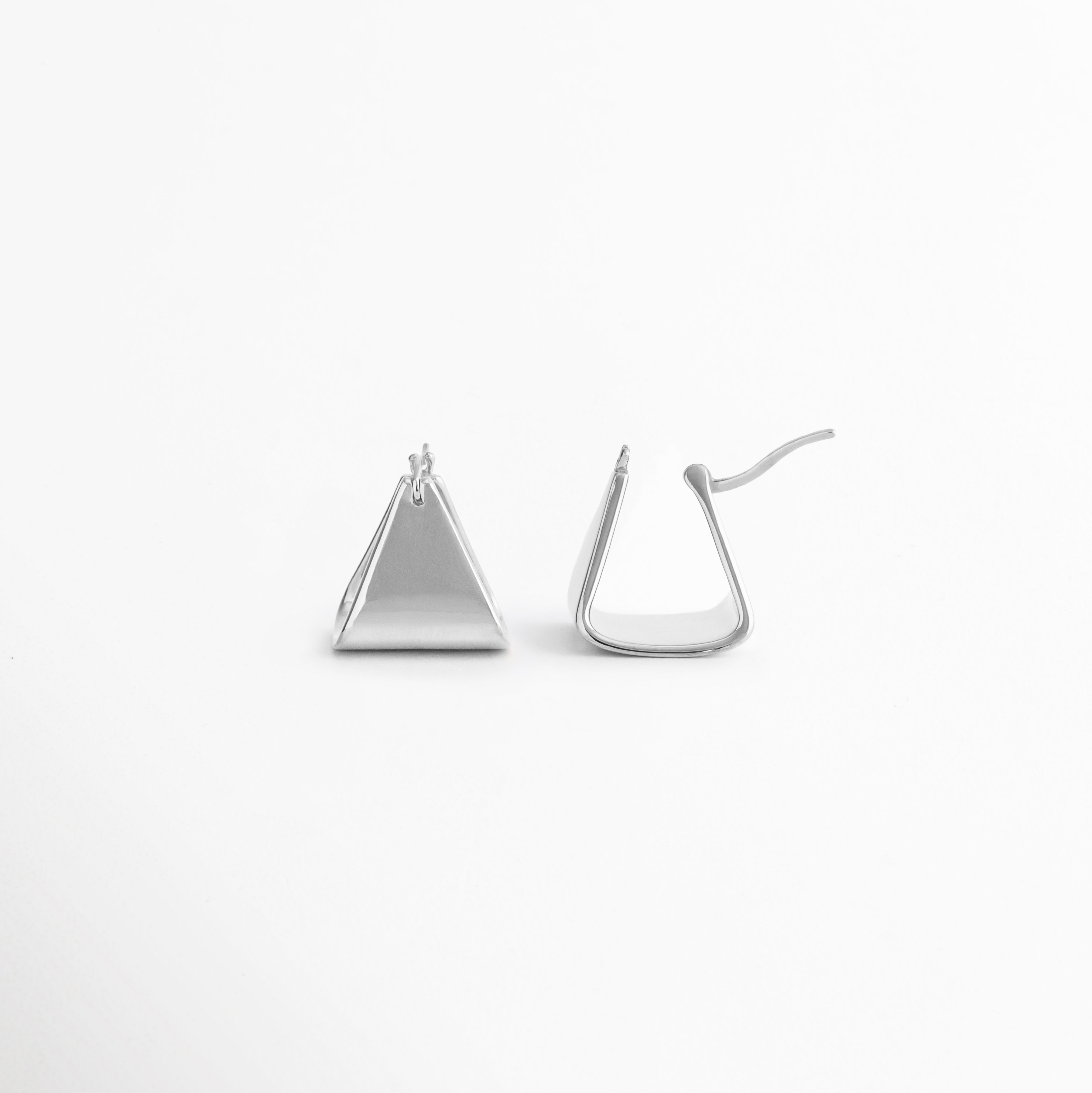 Parte trasera de los aretes Silver Corot mostrando su sistema de cierre seguro y cómodo, Vista posterior de pendientes triangulares Silver Corot con acabado pulido en tono plata, Detalle del broche de los aretes Silver Corot, diseñados para un ajuste práctico y ligero, Aretes geométricos Silver Corot vistos desde atrás, resaltando su construcción sencilla y funcional, Cierre posterior de los aretes Silver Corot con diseño minimalista para uso diario.