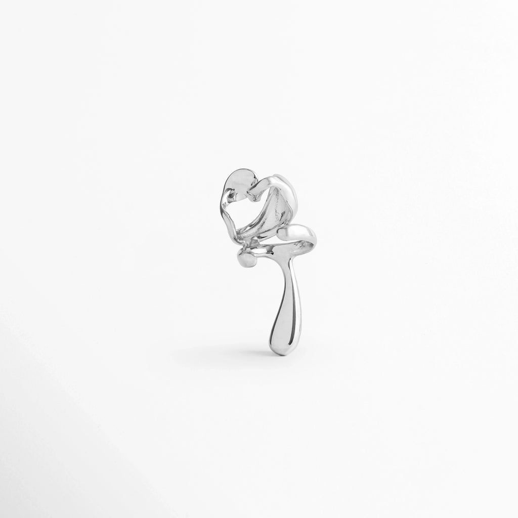 Vista posterior del Ear Cuff Silver Frago enfocando la apertura de agarre que se desliza sobre la oreja toma detallada de la estructura continua y pulida del ear cuff plateado sin perforación, Acercamiento al acabado en tono plata y la superficie metálica lisa de alta calidad del ear cuff, Muestra de la apertura ergonómica del arete de presión plateado de 1.6 cm de ancho.