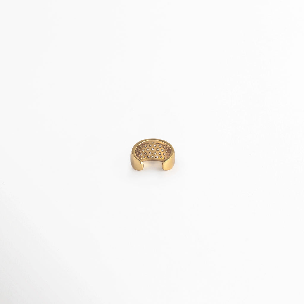 Vista de perfil posterior del Elara Golden Ear Cuff mostrando la abertura del aro para deslizar cómodamente sobre la oreja, Acercamiento a la cavidad interna pulida en acabado dorado espejo del ear cuff de 0.8 cm de ancho, Toma centrada de la estructura en C del arete de presión sin perforación sobre fondo blanco,  Muestra del mecanismo ajustable y bordes suaves de la caña de cobre enchapada en oro