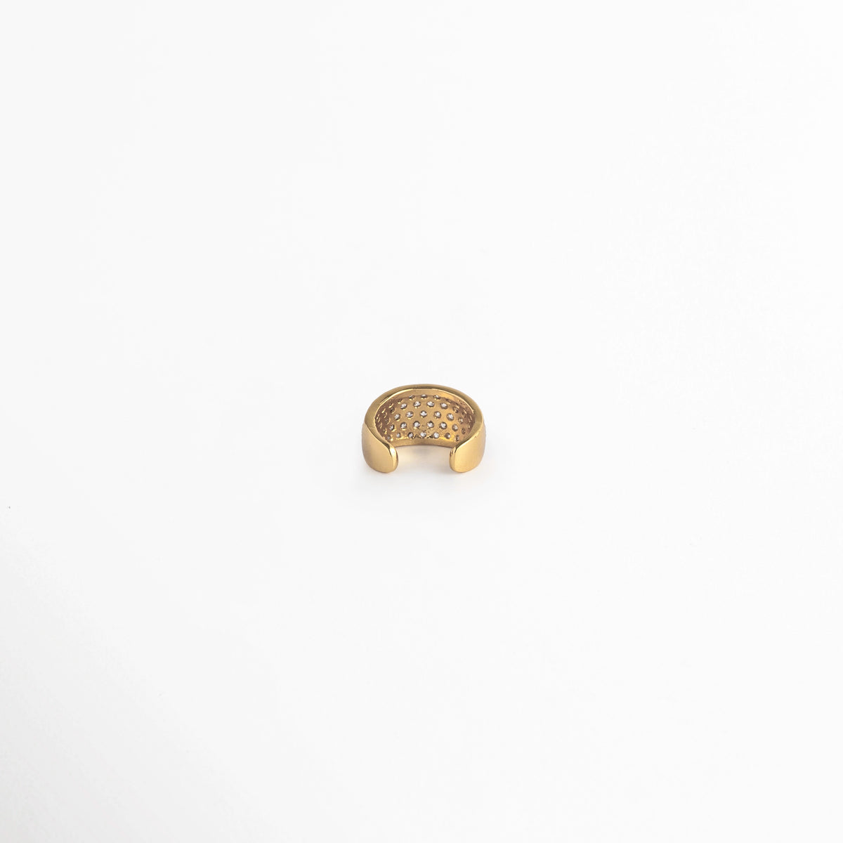 Vista de perfil posterior del Elara Golden Ear Cuff mostrando la abertura del aro para deslizar cómodamente sobre la oreja, Acercamiento a la cavidad interna pulida en acabado dorado espejo del ear cuff de 0.8 cm de ancho, Toma centrada de la estructura en C del arete de presión sin perforación sobre fondo blanco,  Muestra del mecanismo ajustable y bordes suaves de la caña de cobre enchapada en oro