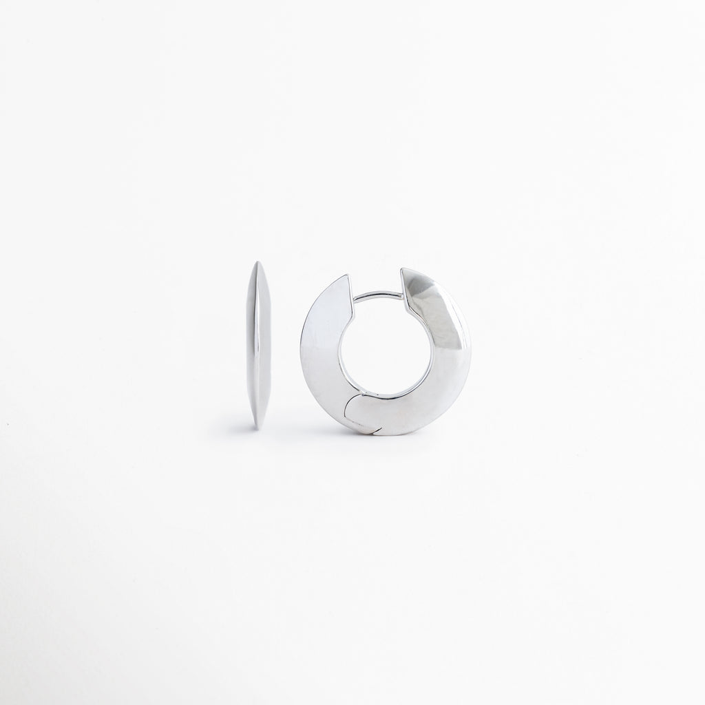 Vista lateral de los aretes Silver Maelis que resalta su perfil estilizado y diseño moderno tipo aro, Aretes Silver Maelis vistos de costado mostrando su estructura ligera y acabado brillante en oro blanco, Perfil lateral de pendientes geométricos Silver Maelis con líneas limpias y estética contemporánea, Detalle lateral de aretes tipo aro ovalado Silver Maelis elaborados en cobre con recubrimiento plateado, Perspectiva lateral de los aretes Silver Maelis destacando su diseño minimalista y elegante.