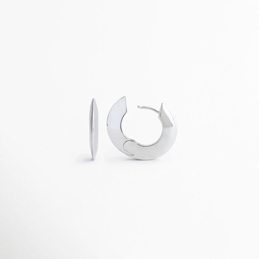 Vista inclinada de los aretes Silver Maelis que permite apreciar su forma ovalada y acabado brillante, Aretes tipo aro Silver Maelis en perspectiva frontal mostrando su diseño geométrico moderno y sofisticado, Detalle de pendientes Silver Maelis con silueta ovalada y acabado plateado de alto brillo, Aretes minimalistas Silver Maelis con diseño versátil y contemporáneo para cualquier ocasión, Vista complementaria de los aretes Silver Maelis destacando su estructura ligera y elegante.