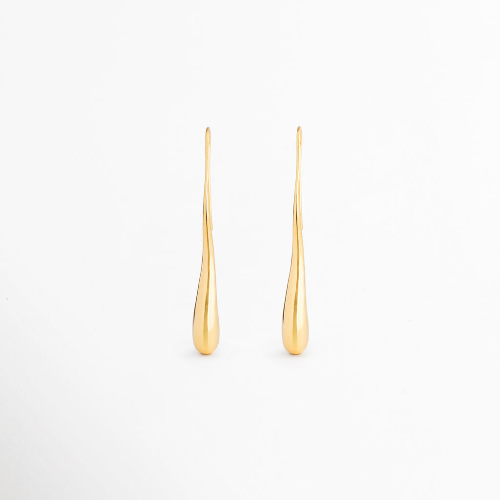 Aretes Soline largos con silueta tipo lágrima y acabado dorado brillante en oro 18K, ideales para looks elegantes y sofisticados,Pendientes Soline de diseño alargado y minimalista con forma de gota, elaborados en latón con recubrimiento en oro 18K, Aretes dorados Soline con estilo refinado de inspiración vintage y acabado pulido de alto brillo, Aretes tipo lágrima largos para mujer, diseño elegante que estiliza el rostro y aporta un toque de lujo sutil, Pendientes Soline con caída delicada y acabado dorado