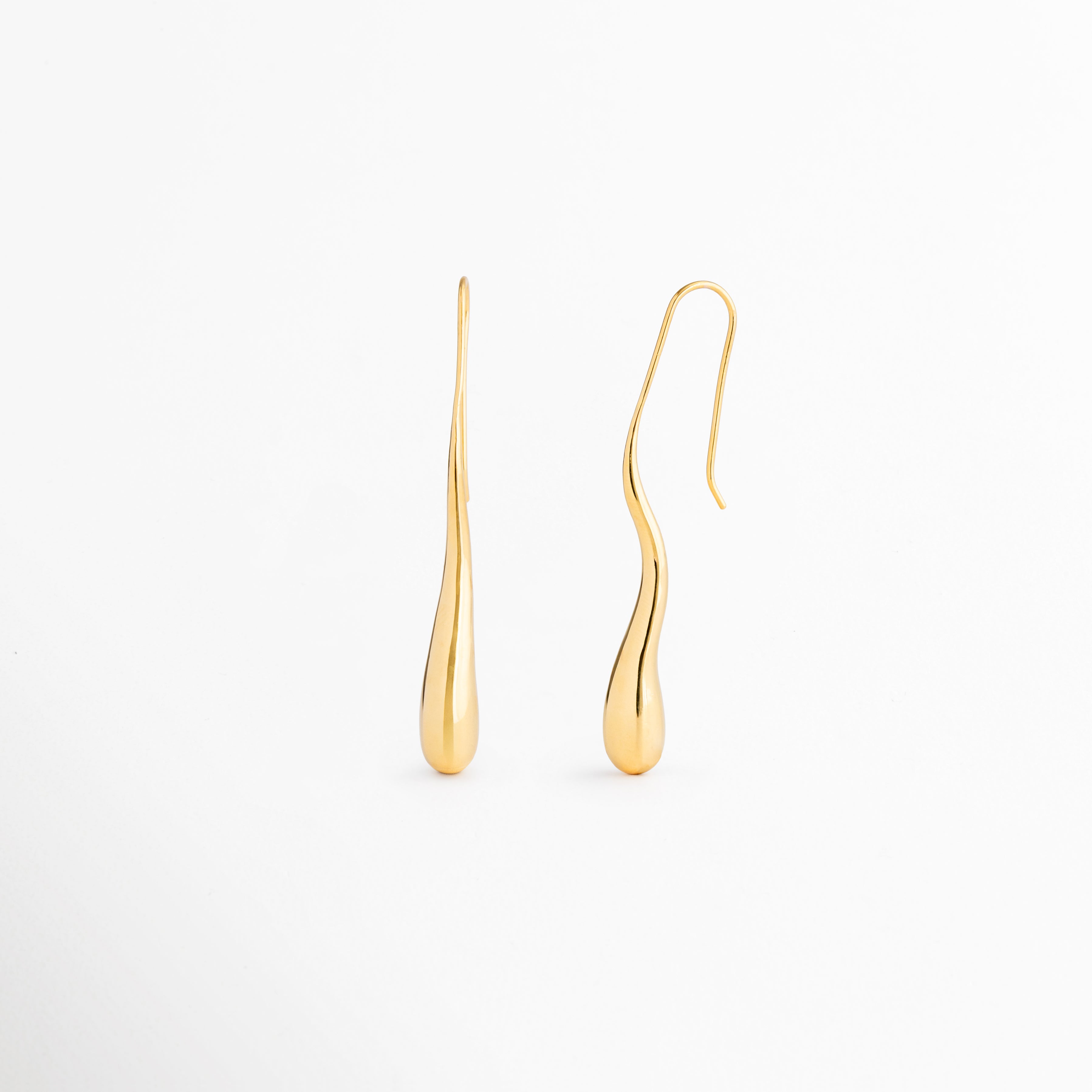 Vista lateral de los aretes Soline que muestra su perfil estilizado y diseño ligero de inspiración vintage, Aretes Soline vistos de costado destacando su elegante silueta alargada tipo lágrima, Perfil lateral de pendientes dorados Soline con acabado pulido en oro 18K y caída sofisticada, Detalle lateral de los aretes Soline elaborados en latón con diseño femenino y refinado, Aretes largos Soline en perspectiva lateral que resaltan su forma fluida y elegante movimiento.