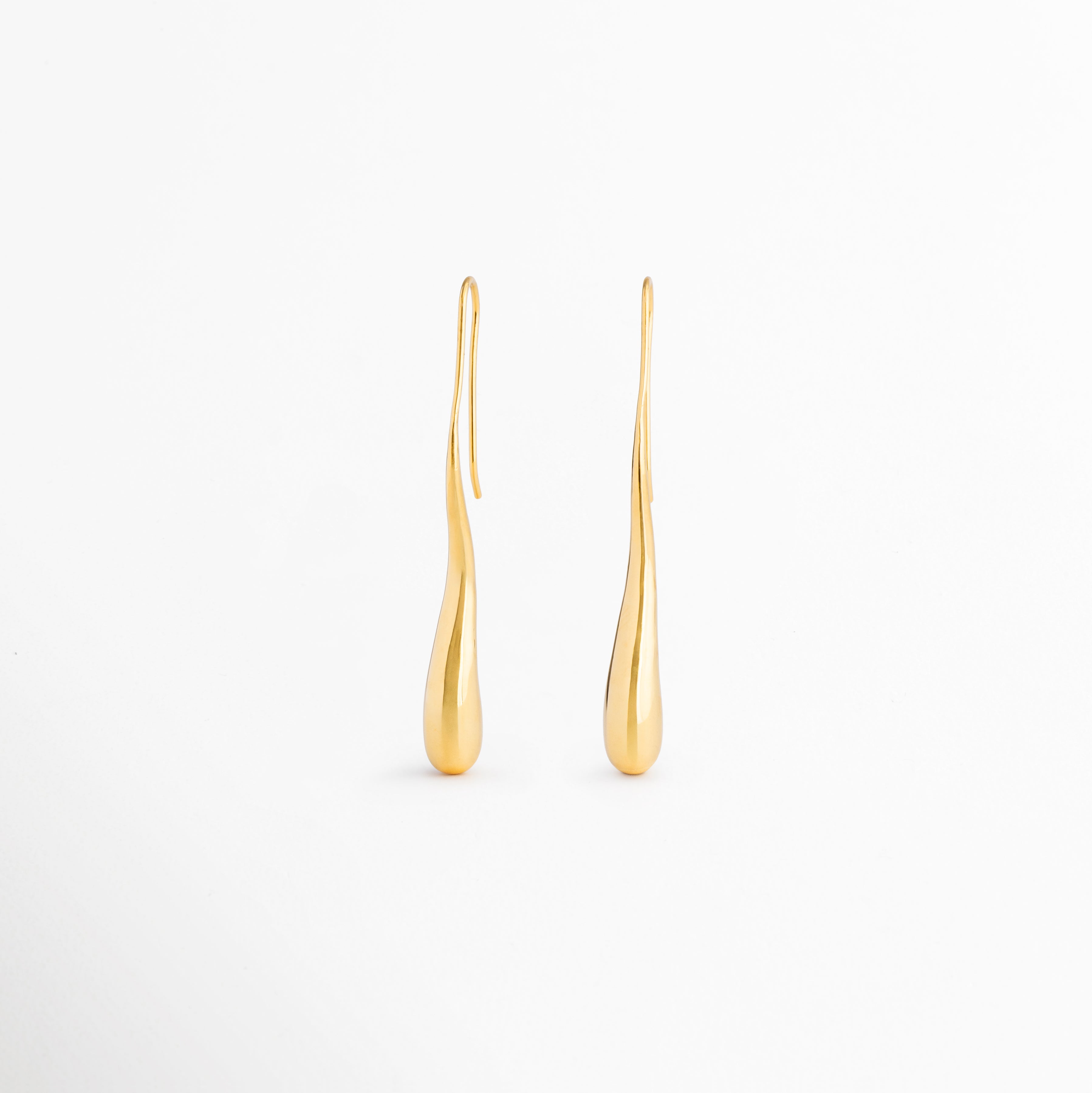 Vista posterior de los aretes Soline mostrando su estructura ligera y sistema de colocación cómodo, Parte trasera de los pendientes Soline con acabado dorado brillante y diseño estilizado, Detalle posterior de aretes largos tipo lágrima Soline elaborados en latón con recubrimiento en oro 18K, Aretes Soline vistos desde atrás destacando su construcción elegante y minimalista, Vista trasera de pendientes dorados Soline con diseño sofisticado para complementar cualquier ocasión especial.