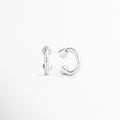 Perfil de los Aretes Virel con diseño geométrico y acabado en Plata 925, Vista lateral de aretes plateados modernos con estructura estilizada, Detalle del cierre y forma contemporánea de los Aretes Virel, Aretes plateados de diseño minimalista vistos de perfil, Vista lateral de aretes elegantes con acabado brillante y líneas limpias.